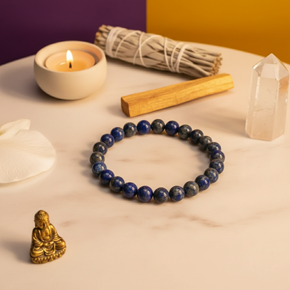 Blue beaded bracelet on a table with a candle, incense, and crystal